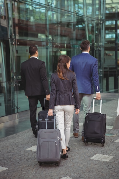 Dirigeants d'entreprise marchant avec une valise à l'extérieur de la plate-forme