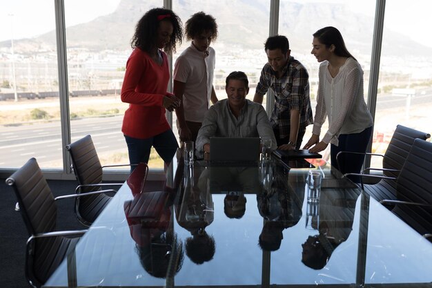 Photo des dirigeants d'entreprise travaillant sur un ordinateur portable dans une salle de conférence