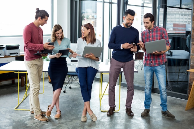 Dirigeants d'entreprise utilisant une tablette numérique, un téléphone mobile et un ordinateur portable