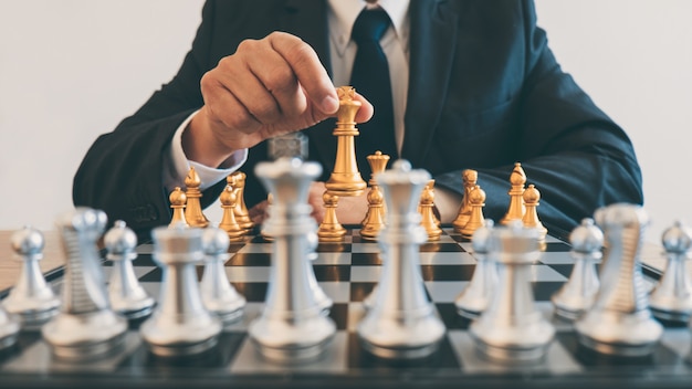 Les dirigeants d’hommes d’affaires jouant aux échecs et réfléchissant au plan stratégique en matière de crash renversent l’équipe opposée et analysent les développements