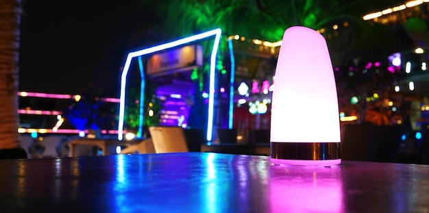 Discothèque, bar, café. Bar de club de plage tropicale la nuit avec des lumières violettes, vertes et bleues