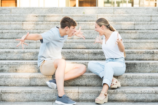 Discussion de couple adolescent assis sur les escaliers