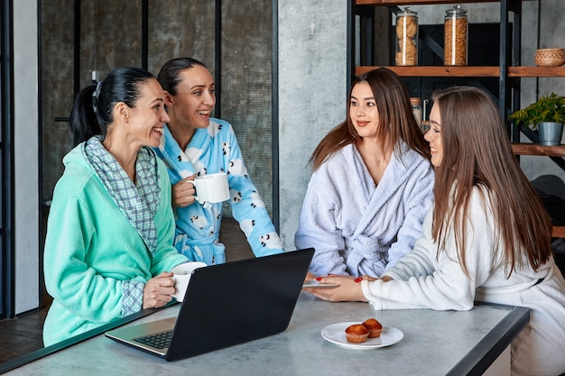 Discussion de fête de famille au petit-déjeuner quatre femmes en robes de chambre discutant joyeusement à table