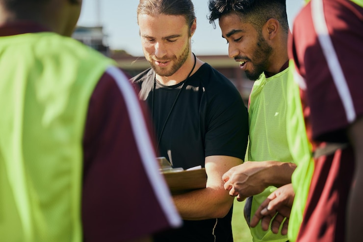 Photo discussion sur la stratégie sportive et les hommes au rugby pour le travail d'équipe, la planification de la condition physique ou le programme d'entraînement ensemble sur le terrain et un groupe d'athlètes en bonne santé avec un entraîneur pour une conversation sur un jeu ou une mission