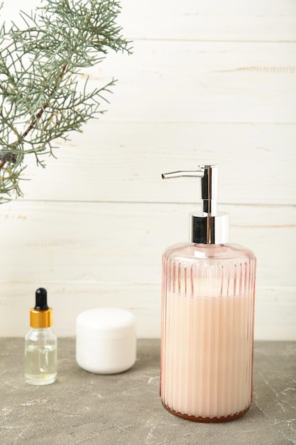 Photo dispensateur de savon avec accessoires de bain sur un fond clair