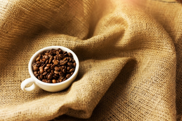 Une dispersion de grains de café avec une tasse de café.