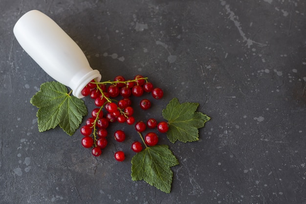 Une dispersion de groseilles rouges tombant d'une bouteille