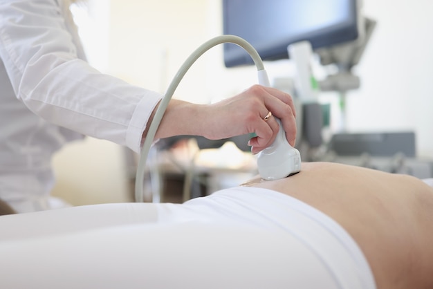 Photo dispositif de balayage d'ultrason dans la main du docteur professionnel examinant son patient