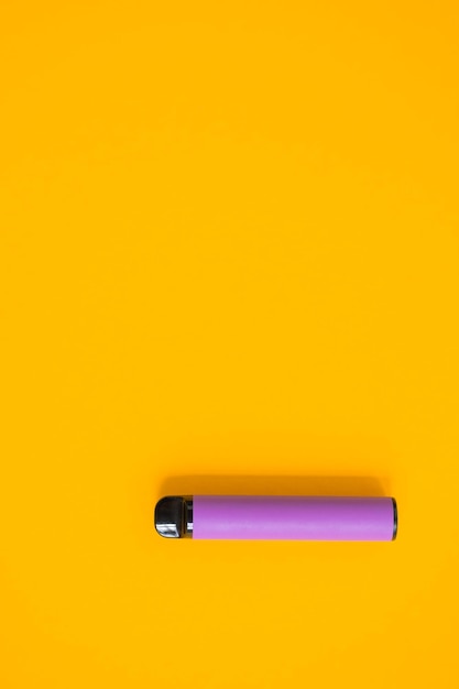 Disposition des cigarettes électroniques jetables colorées avec des ombres sur fond jaune