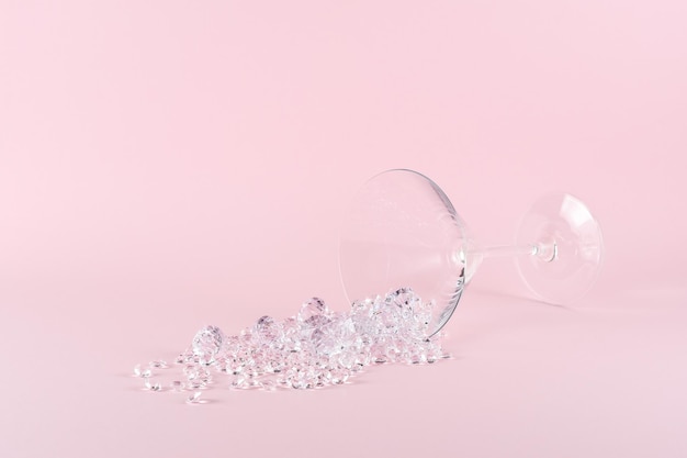 Disposition créative faite de verre à cocktail martini avec diamants sur fond rose pastel Concept de fête minimal