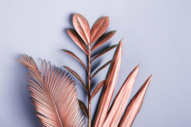 Disposition créative naturelle faite de feuilles tropicales dans des couleurs métalliques roses Fond de surréalisme minimal