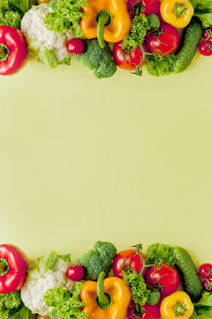 Disposition saine et propre, nourriture végétarienne et concept de nutrition diététique. Divers ingrédients de légumes frais pour salade sur fond de tableau jaune, vue de dessus, cadre, bannière.