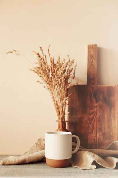 Disposition de la scène d'automne. une tasse de café, des planches à découper en bois et des fleurs séchées au soleil.