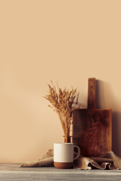 Disposition de la scène d'automne. une tasse de café, des planches à découper en bois et des fleurs séchées au soleil.