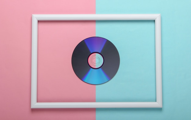 Disque CD dans un cadre blanc sur une surface pastel bleu rose