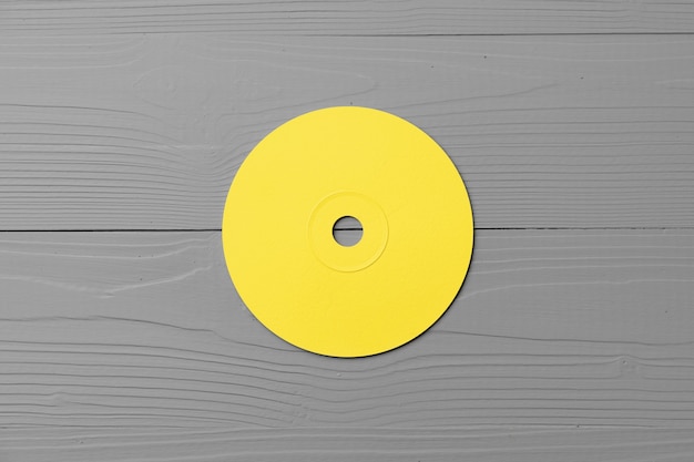 Disque CD jaune sur bois gris