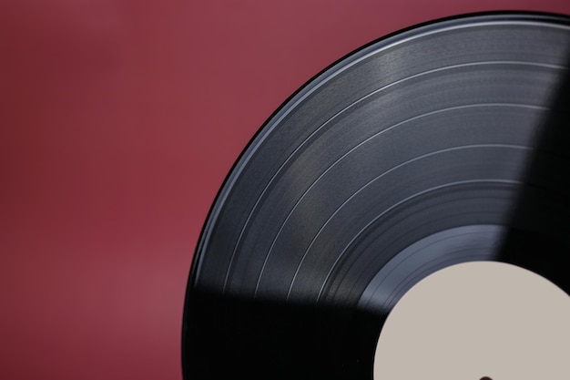 Disque vinyle classique gros plan sur un fond rouge bordeaux musique de stockage de données obsolètes