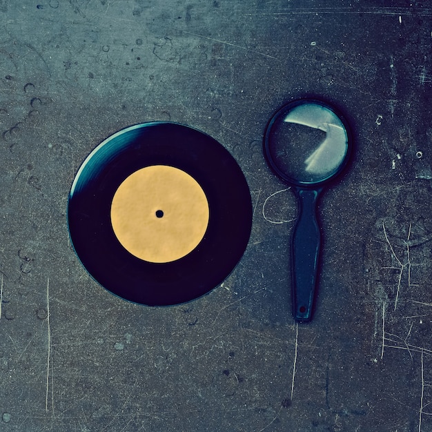 Disque vinyle et loupe sur table en bois