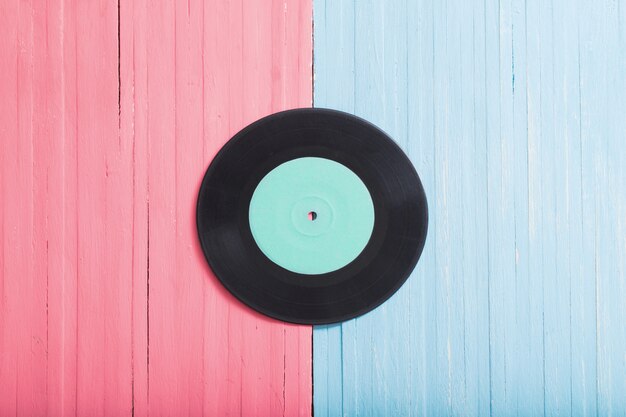 Disques de musique sur fond de bois rose et bleu