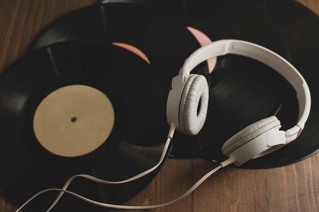 Disques vinyle sur un fond en bois et un casque blanc