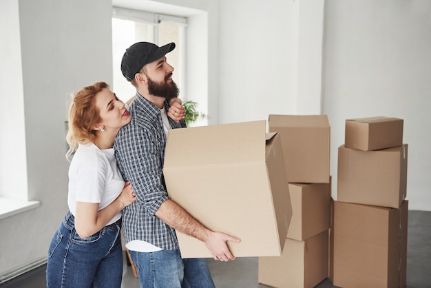 Dit quoi faire. Heureux couple ensemble dans leur nouvelle maison. Conception du déménagement