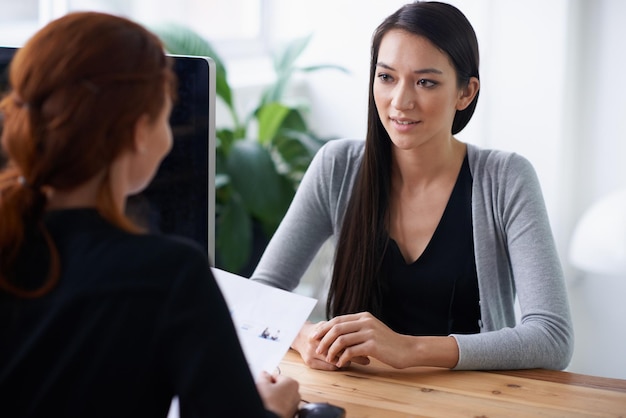 Dites-moi quelque chose sur vous qui ne figure pas dans votre CV Photo de deux jeunes professionnels discutant à un bureau