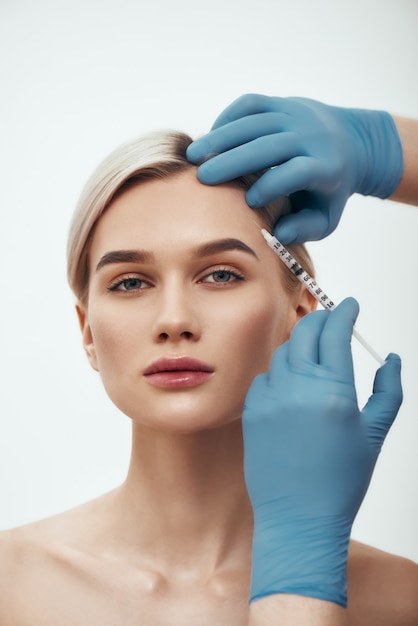 Photo dites non aux rides portrait d'une jeune jolie femme regardant la caméra pendant que les médecins remettent