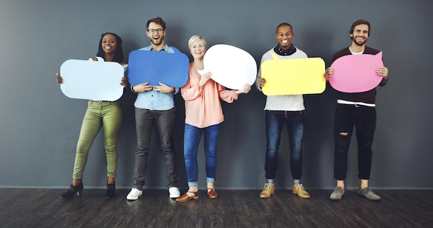 Dites ce que vous pensez Prise de vue en studio d'un groupe diversifié de personnes tenant des bulles sur un fond gris