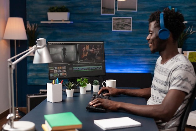 Éditeur cinéaste assis à la table de bureau dans un studio de créativité travaillant à distance de chez lui au montage de films à l'aide d'un logiciel de post-production. Vidéaste éditant des séquences de films créant du contenu pour l'agence