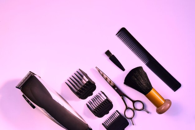 Divers accessoires de coiffure sur un concept de surface rose de l'industrie de la beauté de la coiffure.