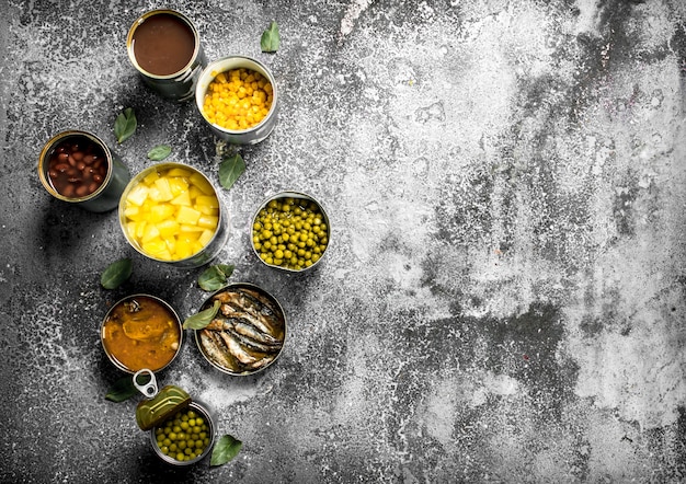 Photo divers aliments en conserve avec de la viande, du poisson, des légumes et des fruits dans des boîtes de conserve