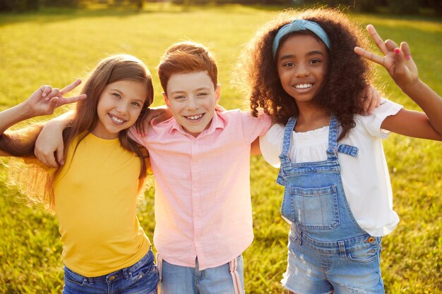 Photo divers amis préadolescents s'embrassant dans le parc