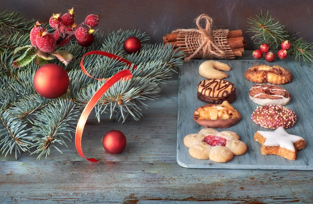 Divers biscuits avec des bâtons de cannelle, des brindilles d'arbre de Noël, des boules et des baies