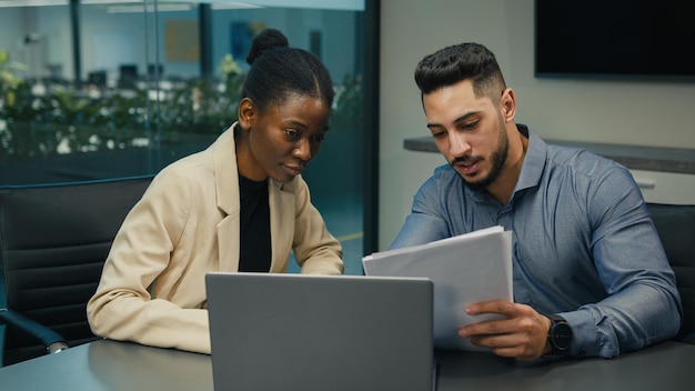 Divers collègues de travail indien arabe et femme afro-américaine travaillant discuter financier