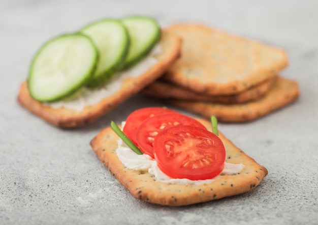 Divers craquelins sains à la crème et tomate au concombre sur une table de cuisine légère