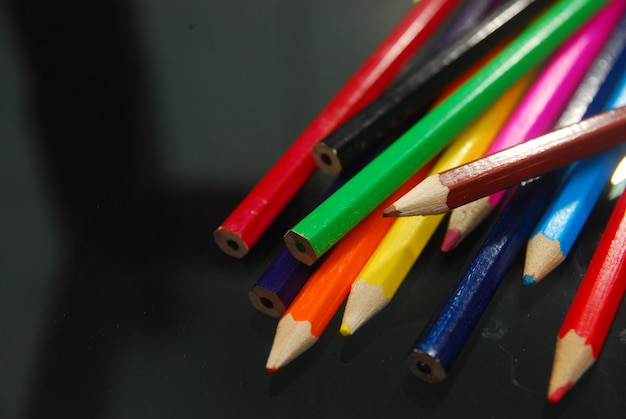 divers crayons de couleur sur fond noir