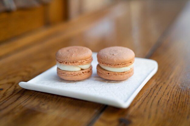 Divers délicieux biscuits macaron sur un support carré