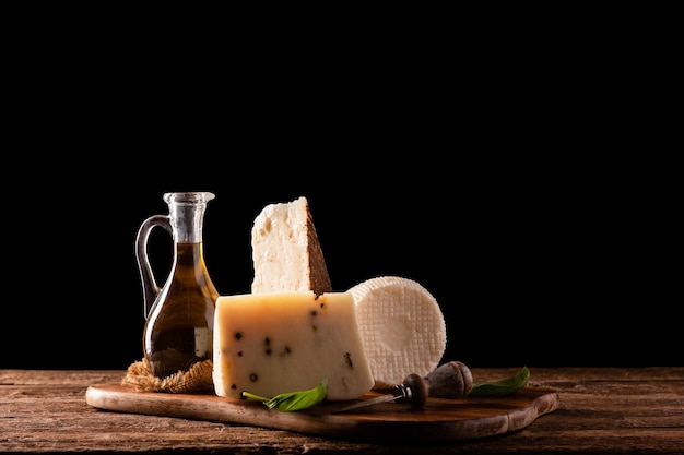 Divers fromages italiens dont l'huile d'olive isolé sur fond noir close up