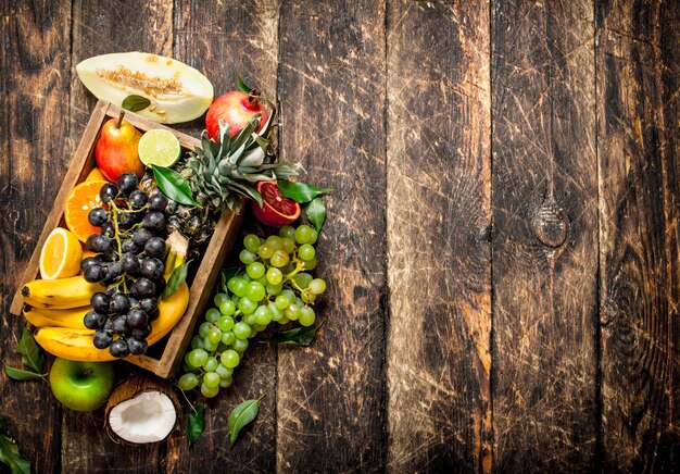 Divers fruits mûrs dans une boîte en bois.