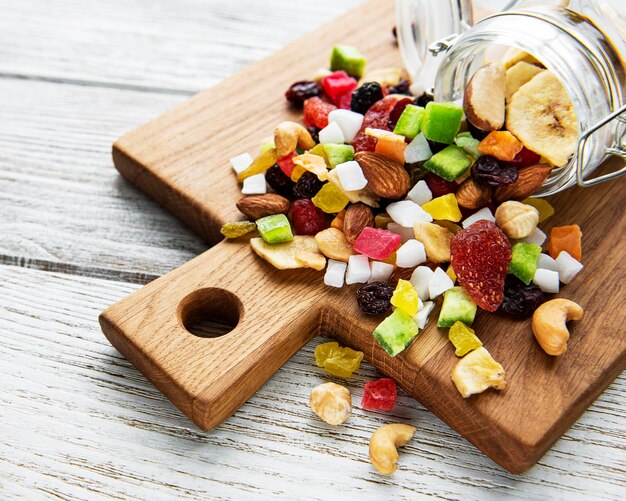 Divers fruits séchés et noix mixtes sur un fond blanc en bois