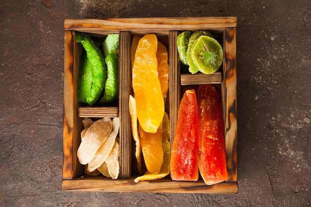 Divers fruits secs dans une boîte en bois, vue de dessus.