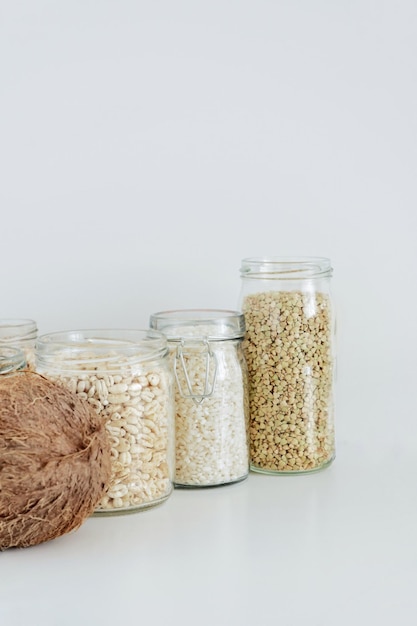 Photo divers grains de céréales crus dans des bocaux en verre le concept de stockage des aliments zéro déchet dans la cuisine