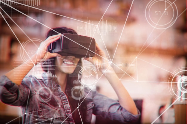 Divers graphiques et points de connectivité contre une jeune femme utilisant le casque de réalité virtuelle