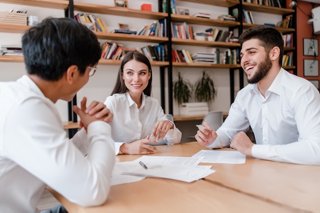 Divers hommes d'affaires au bureau souriant et discutant du travail