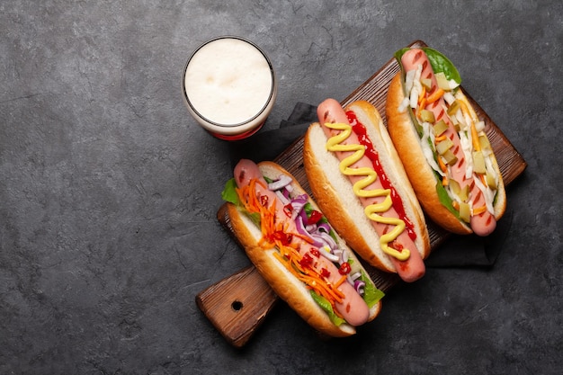 Divers hot-dogs avec des légumes, de la laitue et des condiments