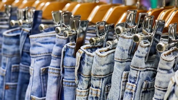 Divers jeans bleus sur une penderie dans le magasin de vêtements