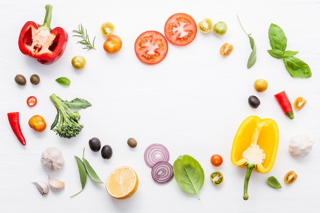 Divers légumes et herbes fraîches sur fond blanc