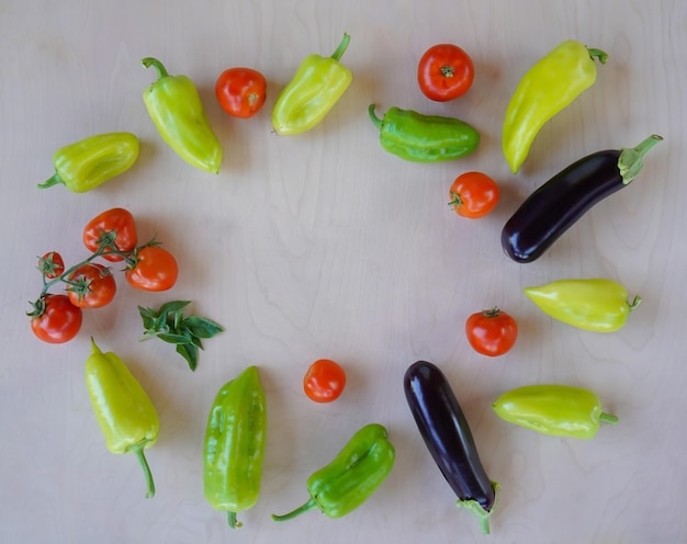 Divers légumes juteux frais se trouvent sur une vue de dessus de fond en bois