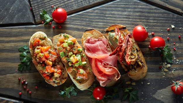 Divers de mini bruschetta avec tomates, saumon, avocat, bacon et basilic