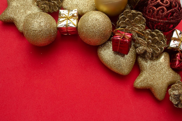 Divers ornements de Noël dorés sur fond rouge